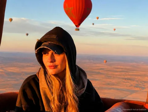 Luchtballon stijgt op bij zonsopgang boven het platteland rond Marrakech
